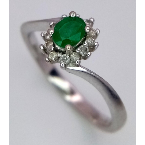 537 - A 18K WHITE GOLD 0.23CT DIAMOND & OVAL EMERALD CLUSTER TWIST RING. TOTAL WEIGHT 2.7G. SIZE M. REF ME... 