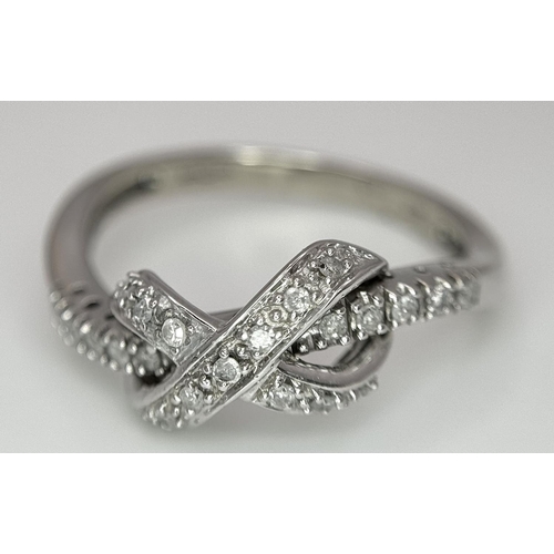 607 - 9K WHITE GOLD DIAMOND SET BOW RING. 2.85G IN WEIGHT. SIZE P. 0.12CT.
Ref: 4957.