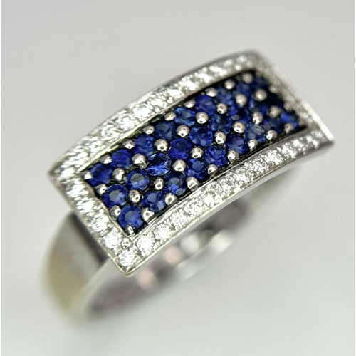 53 - An 18K White Gold Sapphire Ring with Diamond Surround. Size O. 7.4g total weight.