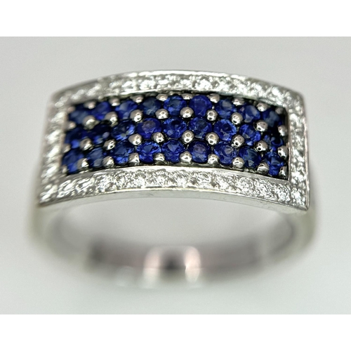 53 - An 18K White Gold Sapphire Ring with Diamond Surround. Size O. 7.4g total weight.