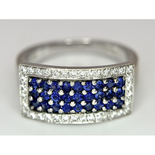 53 - An 18K White Gold Sapphire Ring with Diamond Surround. Size O. 7.4g total weight.