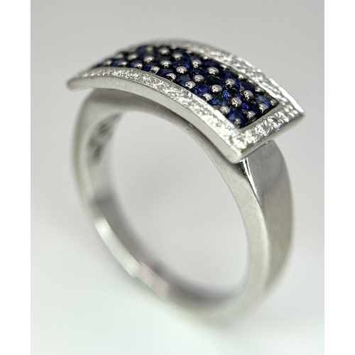 53 - An 18K White Gold Sapphire Ring with Diamond Surround. Size O. 7.4g total weight.