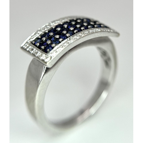 53 - An 18K White Gold Sapphire Ring with Diamond Surround. Size O. 7.4g total weight.