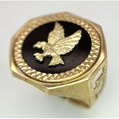 11 - A 9K GOLD RING WITH A FLYING EAGLE FIGURE IN THE CENTRE .     5.2gms    size U