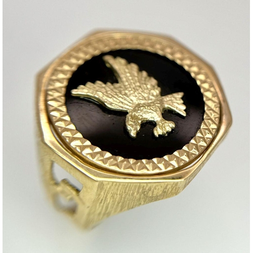 11 - A 9K GOLD RING WITH A FLYING EAGLE FIGURE IN THE CENTRE .     5.2gms    size U