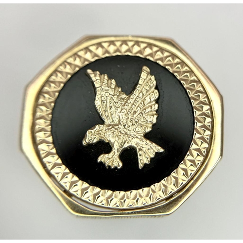 11 - A 9K GOLD RING WITH A FLYING EAGLE FIGURE IN THE CENTRE .     5.2gms    size U