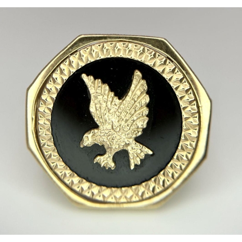 11 - A 9K GOLD RING WITH A FLYING EAGLE FIGURE IN THE CENTRE .     5.2gms    size U