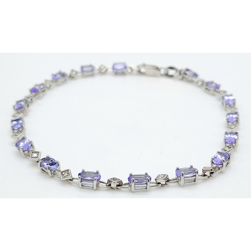 239 - A DIAMOND AND TANZANITE BRACELET IN 9K GOLD .   4.4gms