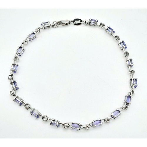 239 - A DIAMOND AND TANZANITE BRACELET IN 9K GOLD .   4.4gms