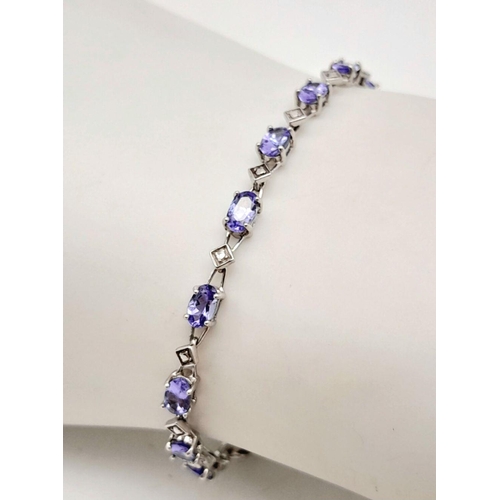 239 - A DIAMOND AND TANZANITE BRACELET IN 9K GOLD .   4.4gms