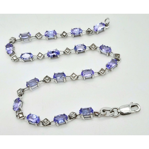 239 - A DIAMOND AND TANZANITE BRACELET IN 9K GOLD .   4.4gms