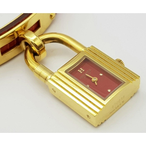 276 - A HERMES OF PARIS NOVELTY PADLOCK ON A BRACELET LADIES WATCH , GOLD PLATED AND ON A RED HERMES LEATH... 