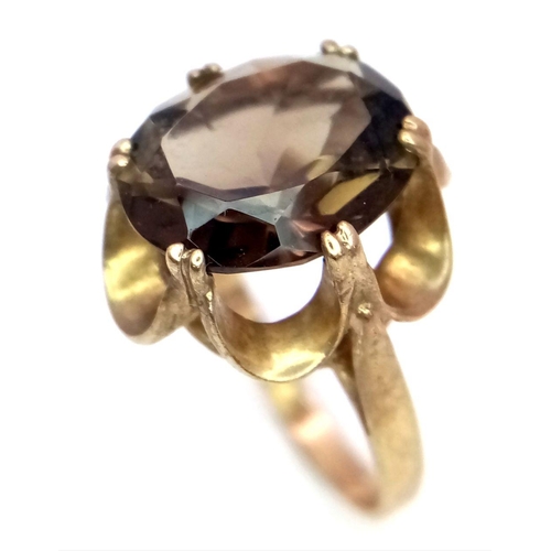 37 - A 9K GOLD DRESS RING WITH LARGE SMOKEY QUARTZ CENTRE STONE  .      3.2gms    size J