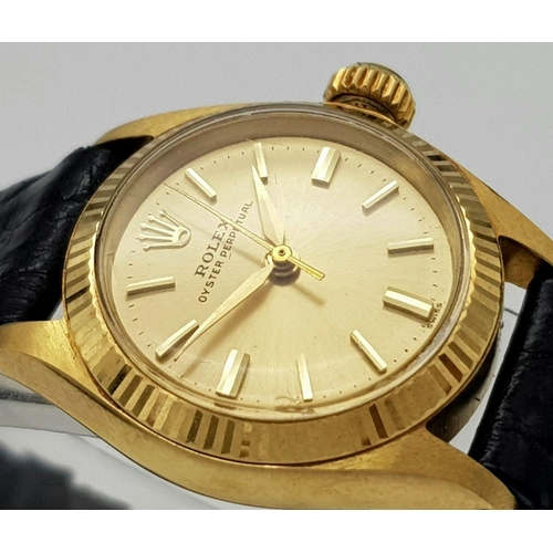 45 - A LADIES ROLEX OYSTER PERPETUAL IN 18K GOLD WITH THE ORIGINAL ROLEX BLACK LEATHER STRAP.    26mm