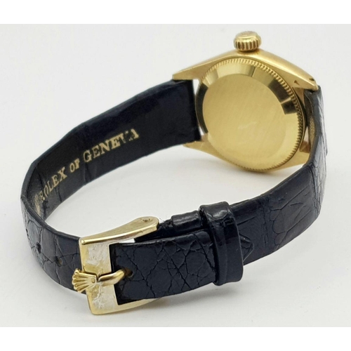 45 - A LADIES ROLEX OYSTER PERPETUAL IN 18K GOLD WITH THE ORIGINAL ROLEX BLACK LEATHER STRAP.    26mm