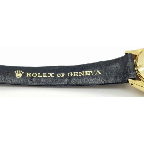 45 - A LADIES ROLEX OYSTER PERPETUAL IN 18K GOLD WITH THE ORIGINAL ROLEX BLACK LEATHER STRAP.    26mm