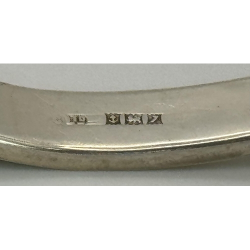 512 - A Sterling silver engraved bangle with bird motif and safety chain. 6.5cm wide, 16.1g in total weigh... 