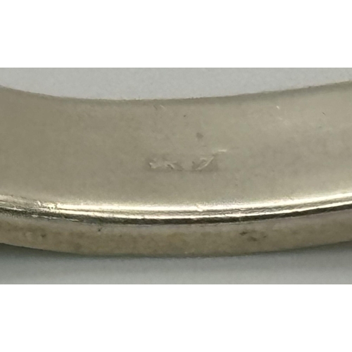 512 - A Sterling silver engraved bangle with bird motif and safety chain. 6.5cm wide, 16.1g in total weigh... 