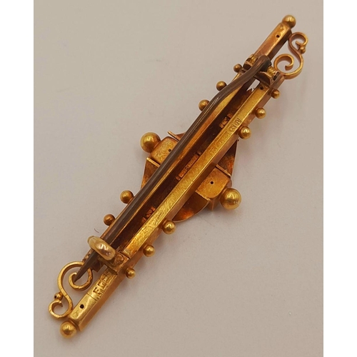 58 - A 15K GOLD ART DECO BROOCH WITH RUBIES AND A DIAMOND .   3.1gms