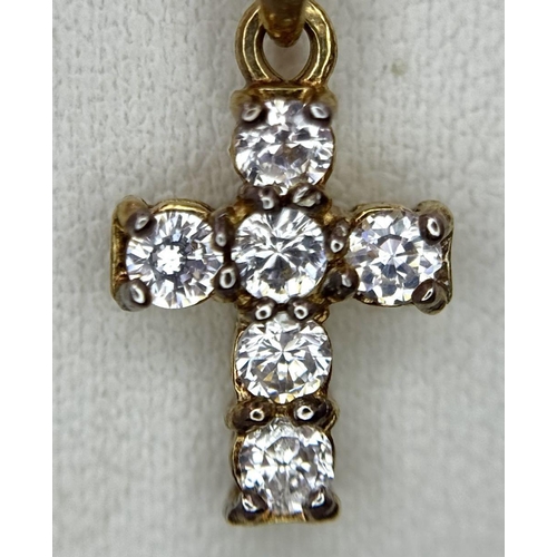 87 - A VERY PRETTY STONE SET CROSS PENDANT IN 9K GOLD AND ON AN 40cms DISAPPEARING NECK CHAIN .  1.8gms