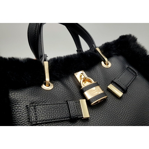 1518 - A Dune of London Handbag. Black textured exterior with gold tone hardware. Faux fur interior lining.... 