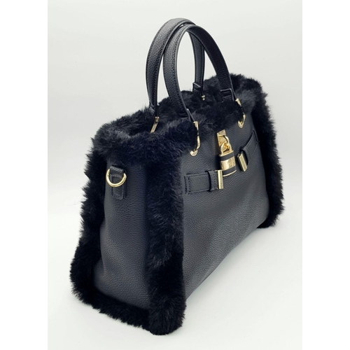 1518 - A Dune of London Handbag. Black textured exterior with gold tone hardware. Faux fur interior lining.... 