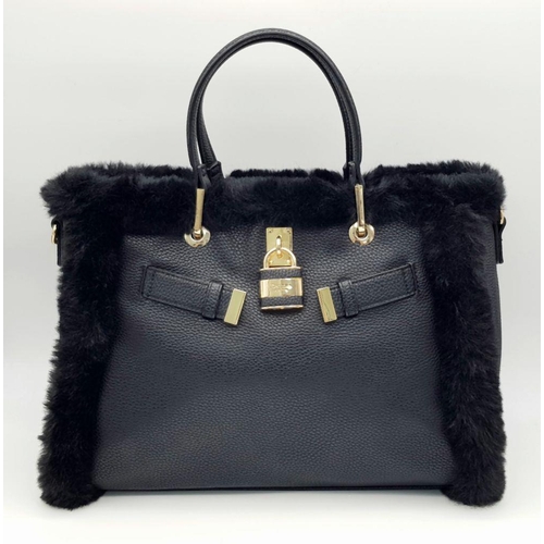 1518 - A Dune of London Handbag. Black textured exterior with gold tone hardware. Faux fur interior lining.... 