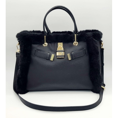 1518 - A Dune of London Handbag. Black textured exterior with gold tone hardware. Faux fur interior lining.... 