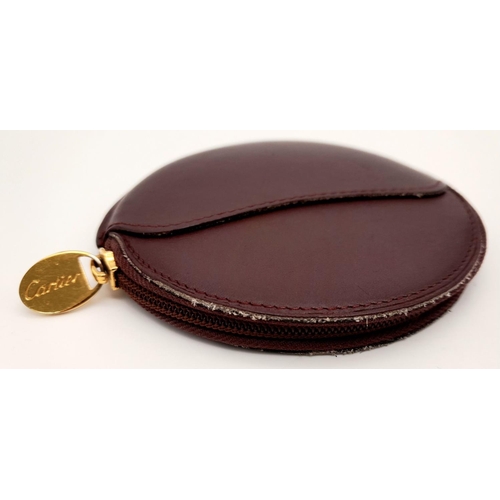 1504 - A Burgundy Cartier Purse. Leather exterior, zipper closure, gold-tone hardware and a open side pocke... 