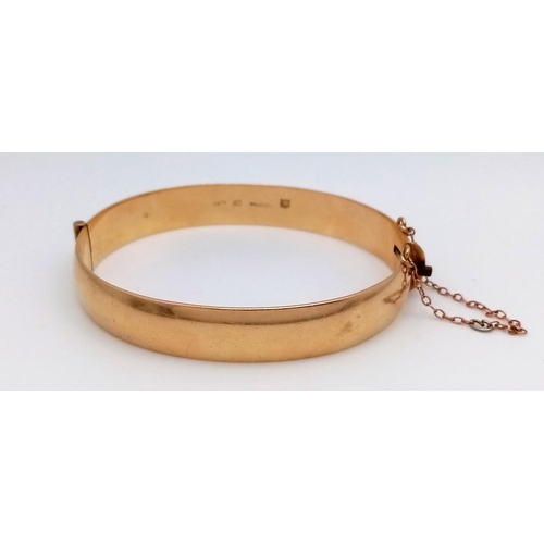 1511 - A stylish 9K yellow rolled gold bangle with floral motif engravings. Come with safety chain. Total w... 