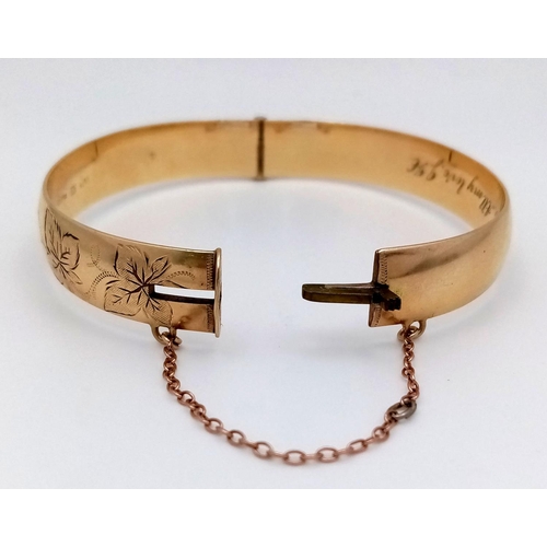 1511 - A stylish 9K yellow rolled gold bangle with floral motif engravings. Come with safety chain. Total w... 