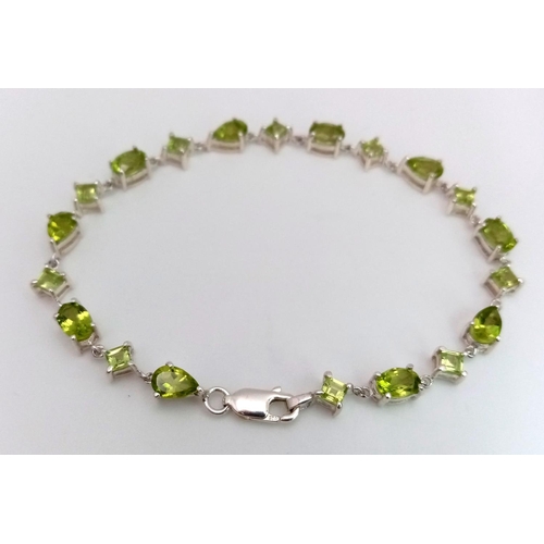 626 - A Sterling Silver, Various Cut, Peridot Set Tennis Bracelet. 18cm Length. Set with Pear, Square and ... 