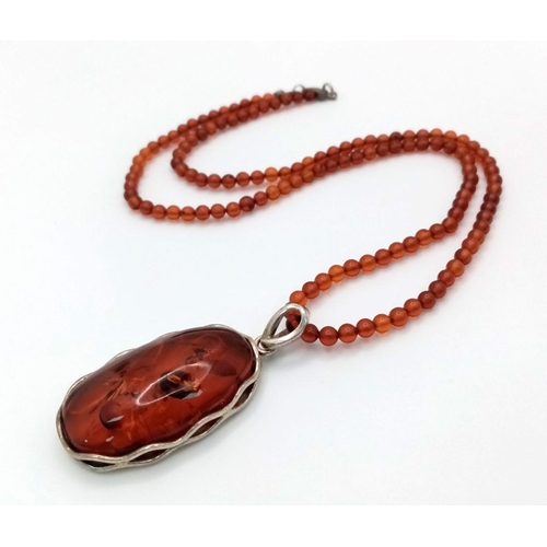 1505 - An Amber pendant in 925 silver settings. Completed with Amber beads necklace. Total weight 19G. Tota... 