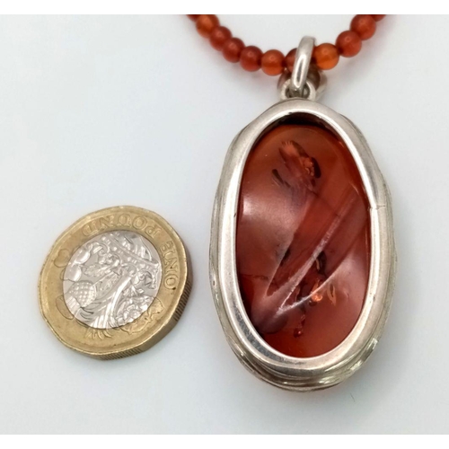 1505 - An Amber pendant in 925 silver settings. Completed with Amber beads necklace. Total weight 19G. Tota... 