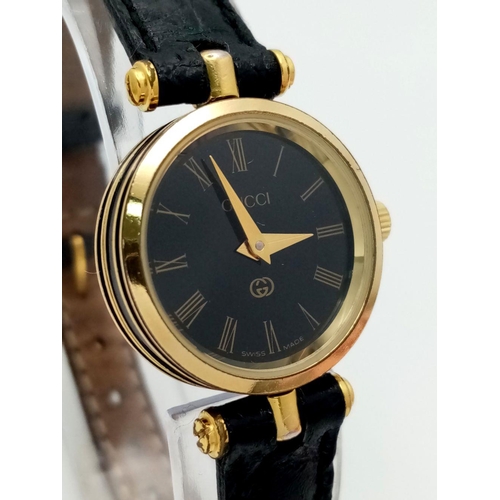 491 - A Designer Gucci Ladies Quartz Watch. Black leather strap with original Gucci clasp. Gold plated and... 