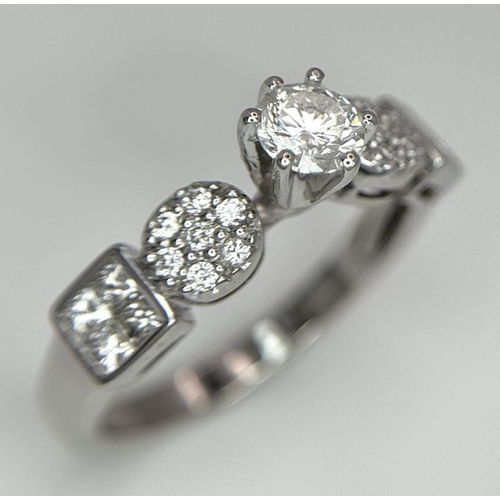 645 - An 18K White Gold and Fancy Diamond Ring. A central 0.40ct brilliant round cut centre stone with pav... 