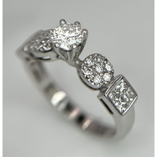 645 - An 18K White Gold and Fancy Diamond Ring. A central 0.40ct brilliant round cut centre stone with pav... 