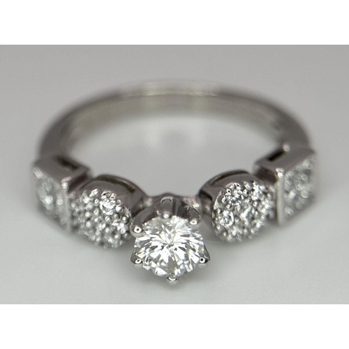 645 - An 18K White Gold and Fancy Diamond Ring. A central 0.40ct brilliant round cut centre stone with pav... 