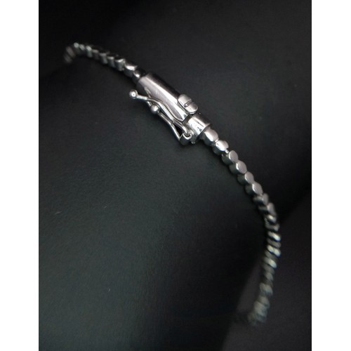 639 - An 18K White Gold and Diamond Bracelet. Graduating floral diamond cluster links that overlap. 1.5ctw... 