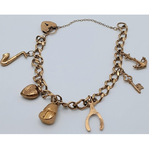 25 - A 9K Yellow Gold Charm Bracelet with Heart Clasp. Six charms including: anchor, sax and Tutankhamun!... 