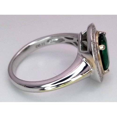 39 - An 18K White Gold, Emerald and Diamond Ring. A hypnotic 2ct oval cut central green emerald with a 0.... 