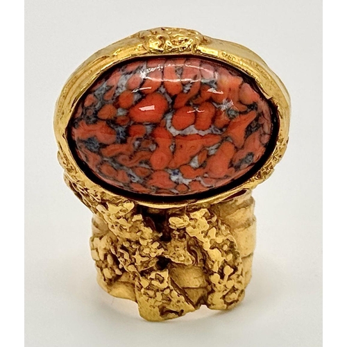 107 - An original, vintage, brutalist styled ring, designed by YSL carrying a large “marbled coral” caboch... 