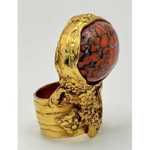 107 - An original, vintage, brutalist styled ring, designed by YSL carrying a large “marbled coral” caboch... 