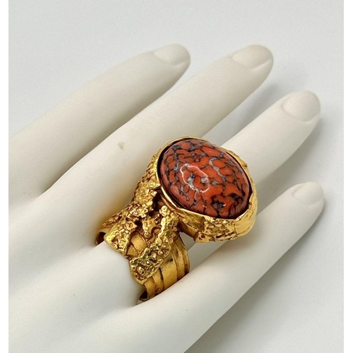 107 - An original, vintage, brutalist styled ring, designed by YSL carrying a large “marbled coral” caboch... 