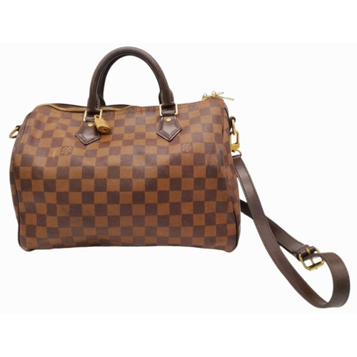 26 - A Louis Vuitton Speedy Bag. Damier Ebene canvas exterior with gold-toned hardware, two rolled leathe... 