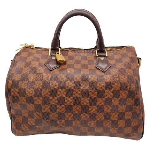 26 - A Louis Vuitton Speedy Bag. Damier Ebene canvas exterior with gold-toned hardware, two rolled leathe... 