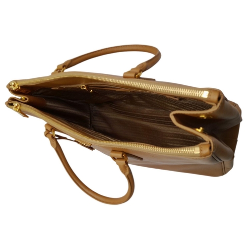 54 - A Prada Camel Large Bag. Leather exterior with gold-toned hardware, two rolled leather handles, four... 