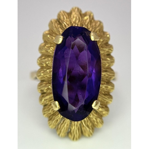 71 - An 18K Yellow Gold Alexandrite Ring. 6ct oval cut central stone on a raised bark-effect setting. Siz... 