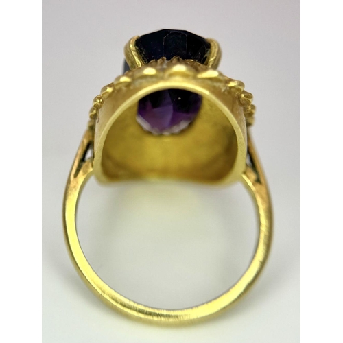 71 - An 18K Yellow Gold Alexandrite Ring. 6ct oval cut central stone on a raised bark-effect setting. Siz... 