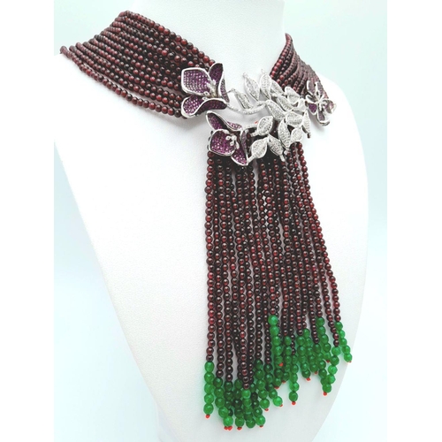 73 - A statement multi gem necklace consisting of eleven strands with a spectacular central floral pendan... 